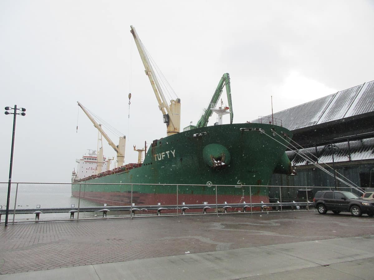 Bulk carrier loading sugar at a refinery quay